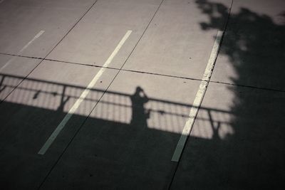 High angle view of person shadow on parking lot