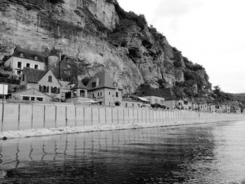 Scenic view of sea by buildings against sky