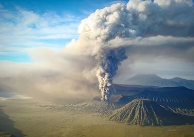 Smoke emitting from volcanic mountain against sky