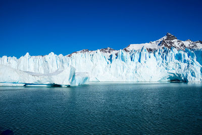 Scenic view of sea against clear blue sky during winter