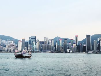 Scenic view of sea and buildings against clear sky