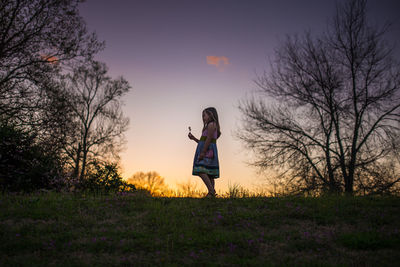 Little girl holding flower silohette long hair summer evening sunset