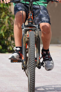 Low section of man riding bicycle on street