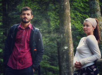 Portrait of young couple standing in forest