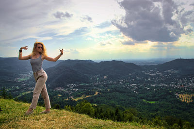 Full length of woman dancing on mountain against sky