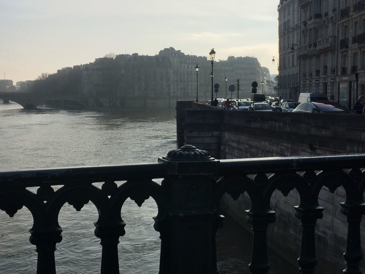 BRIDGE OVER RIVER BY BUILDINGS AGAINST SKY