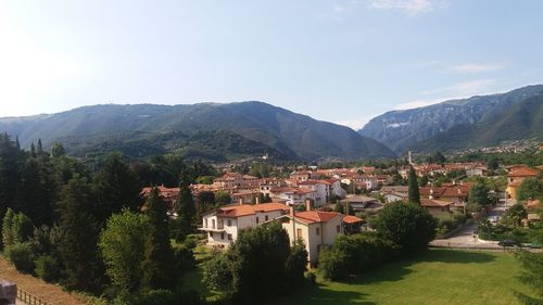 Houses by mountain against sky