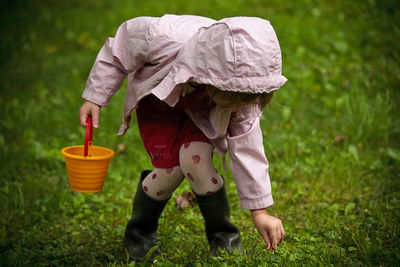 Full length of girl picking plants in park