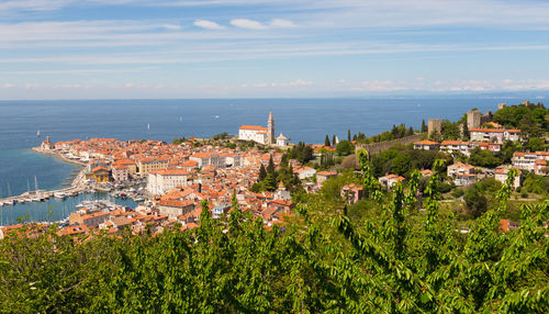 High angle view of townscape by sea against sky