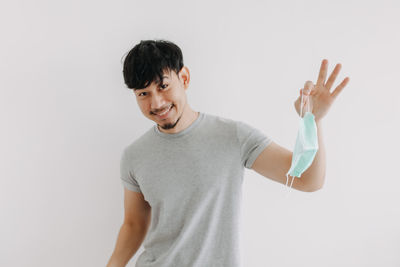 Portrait of smiling man standing against white background