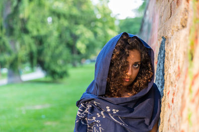 Portrait of woman by tree trunk