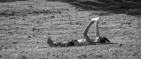 Side view of young woman lying down on land