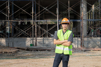 Portrait of man wearing hat standing at construction site