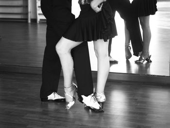 Low section of woman and man standing on hardwood floor