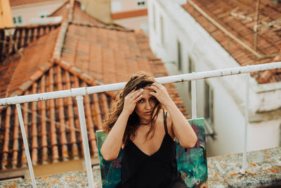 Portrait of woman standing by railing