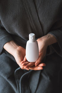 Midsection of woman holding bottle