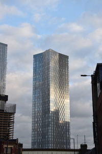 Low angle view of buildings against cloudy sky