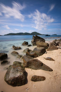 Scenic view of rocks on beach against sky