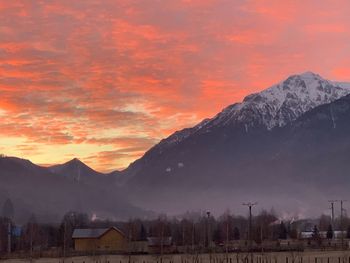 Scenic view of snowcapped mountains against orange sky