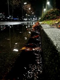 Reflection of illuminated street in city at night