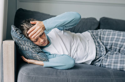 Midsection of woman sitting on sofa at home