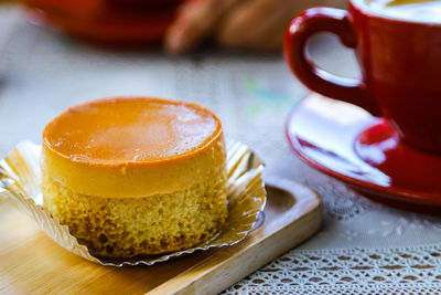 Close-up of coffee cup and  custard cake on table