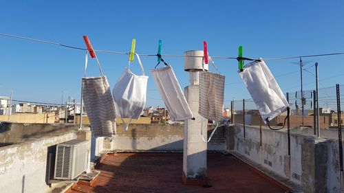 Clothes drying on clothesline by buildings against sky