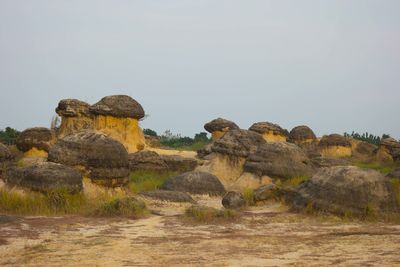 Rocks on field against clear sky