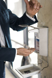 Businessman maintaining safety with washing hands while standing at office