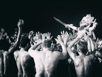 Crowd at music concert against sky at night