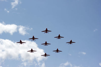 Low angle view of fighter airplane flying against blue sky