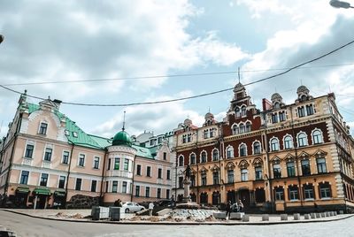 Buildings in city against cloudy sky