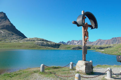 Scenic view of lake and mountains against clear blue sky