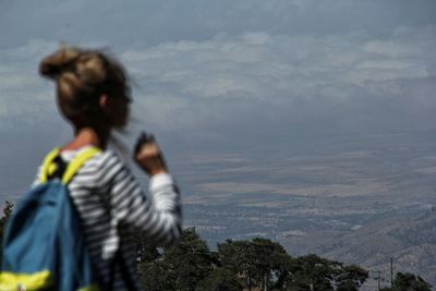 Rear view of woman looking at mountain against sky