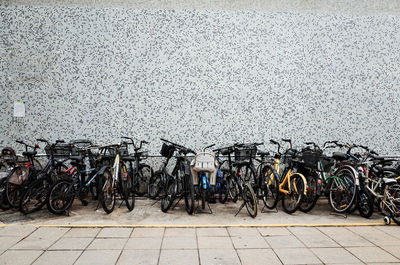 Bicycles parked on street against wall