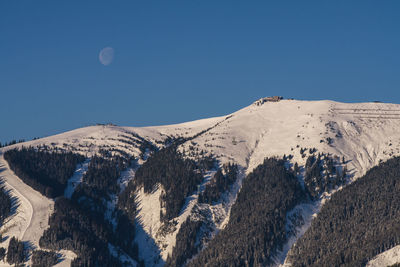 Scenic view of snowcapped mountains against clear blue sky