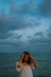 Portrait of woman standing in sea against sky