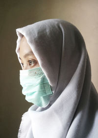 Close-up woman in hijab wearing mask