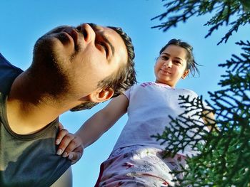 Low angle view of friends against sky