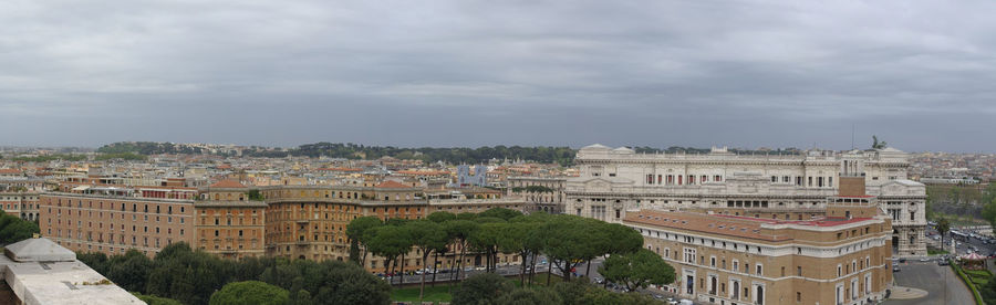 Buildings in city against cloudy sky