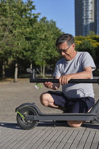 Side view of man sitting on road