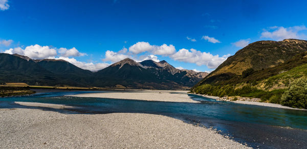 Scenic view of lake and mountains against blue sky