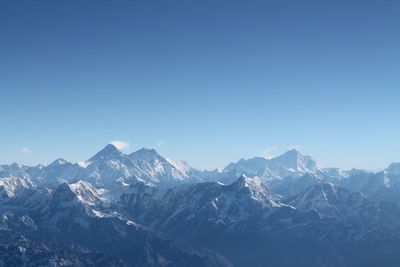 Scenic view of snowcapped mountains against clear blue sky