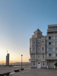 Buildings in city against sky during sunset