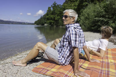 Senior couple sitting at kochelsee lakeshore