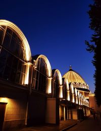 Low angle view of illuminated building against clear blue sky