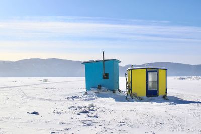 Built structure on snowy field against sky