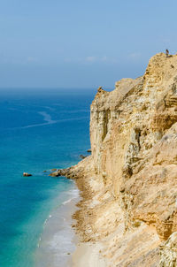 Scenic view of sea by cliff against sky