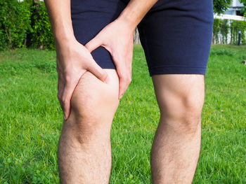 Cropped image of man holding hands on field