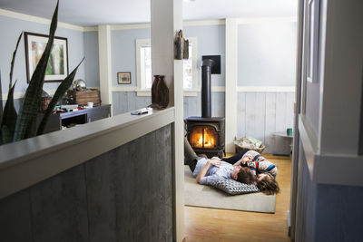 Couple relaxing on floor in living room at home